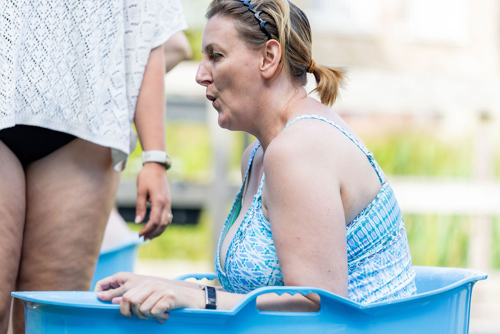 Twee deelnemers samen in het ijsbad tijdens een teambuilding